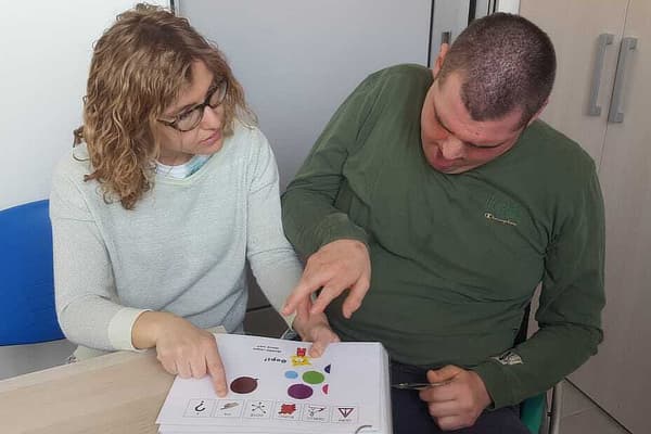 Laura facilita Alex nella lettura di un testo in simboli