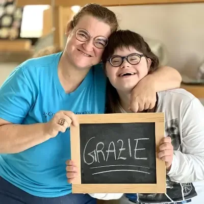 Katia e Sofia mostrano una lavagnetta con la scritta "grazie"